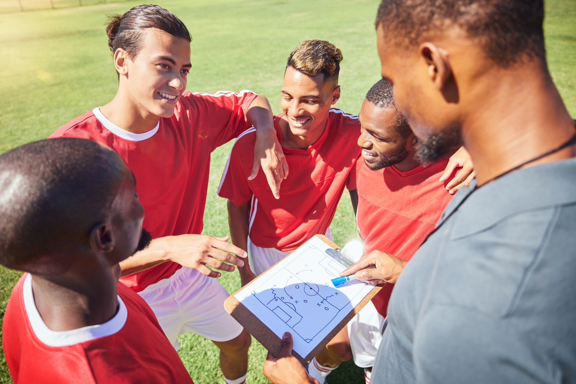 Soccer, team and coaching with strategy, paper and formation with talking, communication and planning. Men football group, coach and clipboard with game instruction on sport pitch or field together